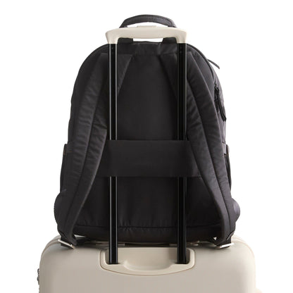 Black backpack with wheels attached to a beige suitcase on a white background